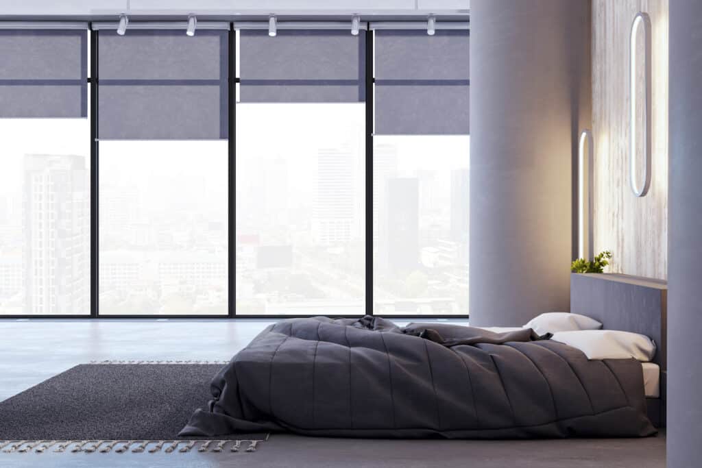 Roller blinds in a modern Adelaide high-rise bedroom with city views and contemporary interior design.