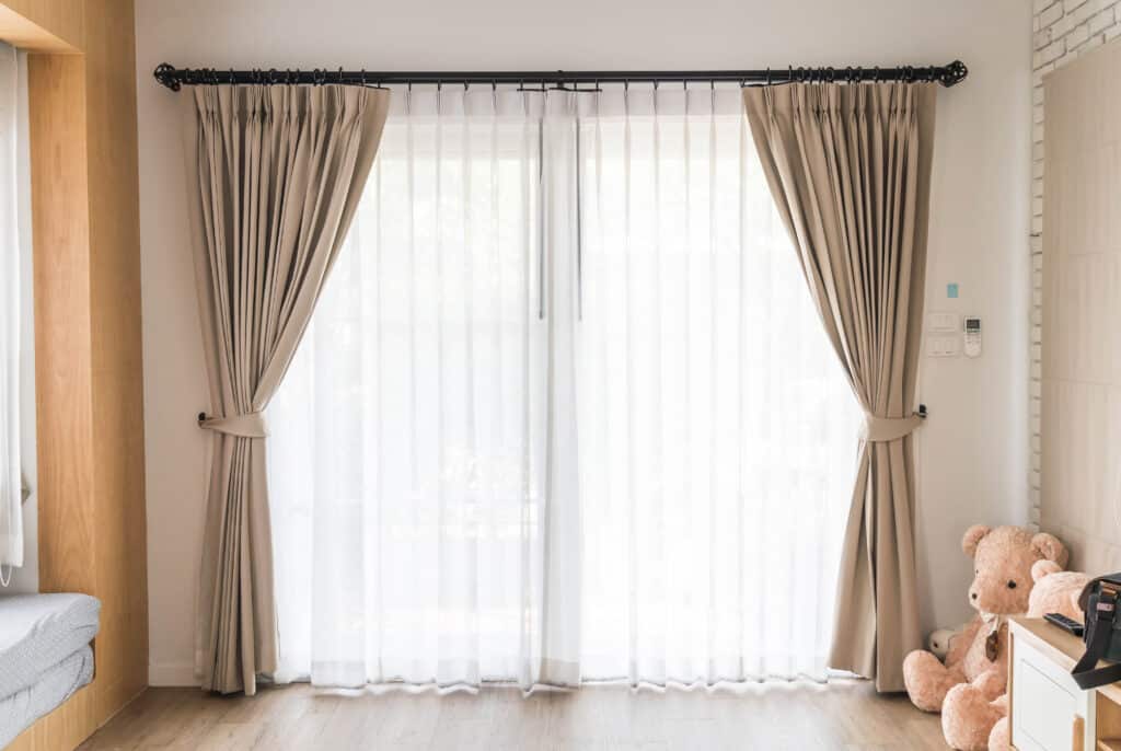 Custom beige curtains in a family living room in Adelaide with soft white sheers and natural light