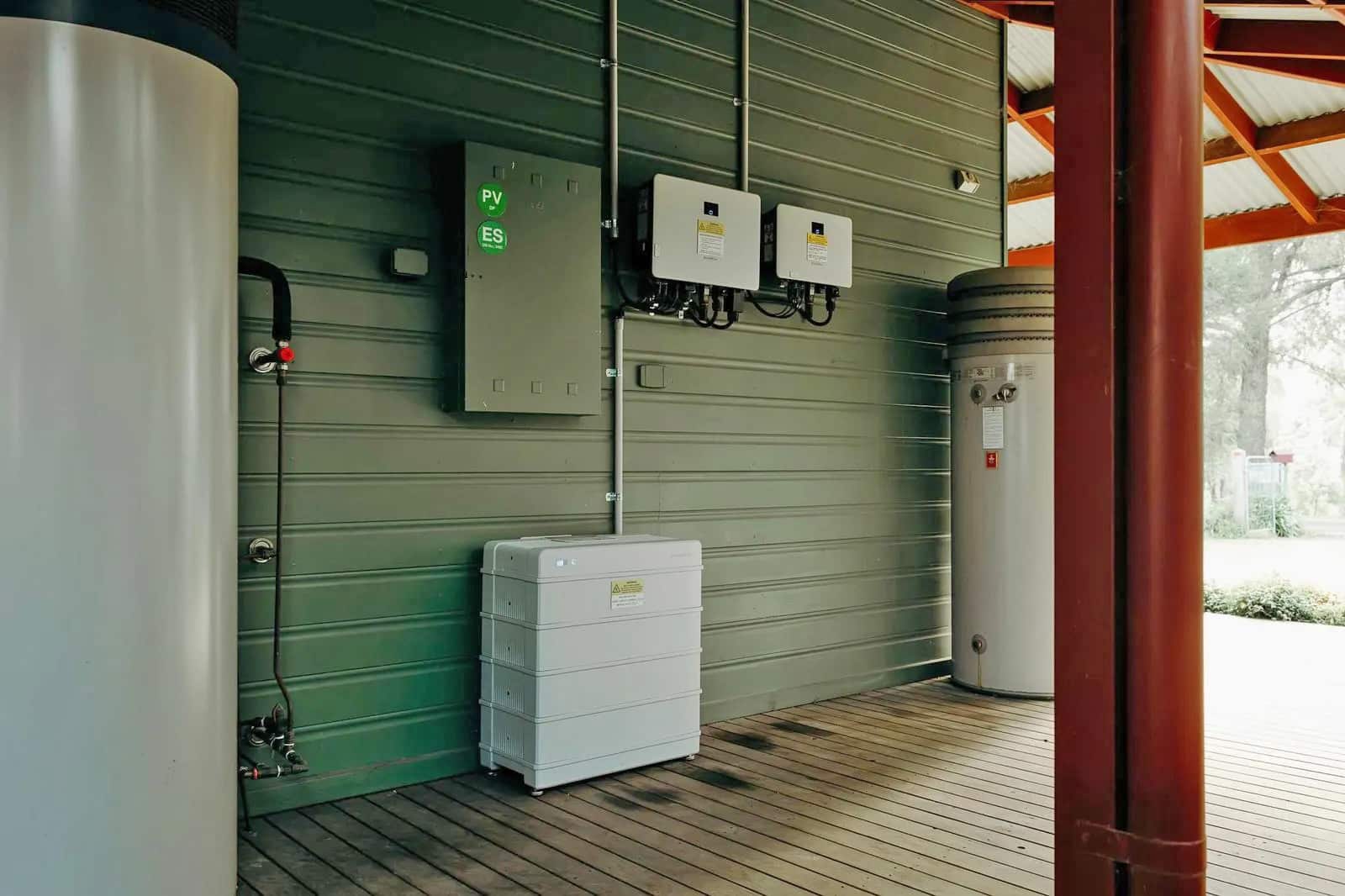 Installed home battery storage unit with connected inverters on exterior wall