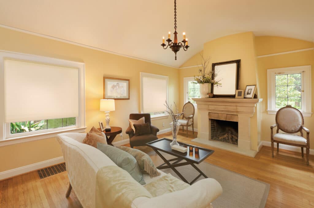 Traditional living room with cream honeycomb blinds in an Adelaide home, featuring a fireplace and warm décor.