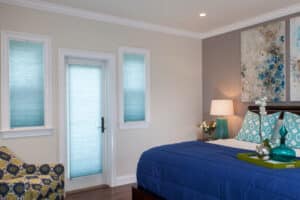 Modern bedroom with teal honeycomb blinds in Adelaide home, paired with contemporary décor and blue bedding.