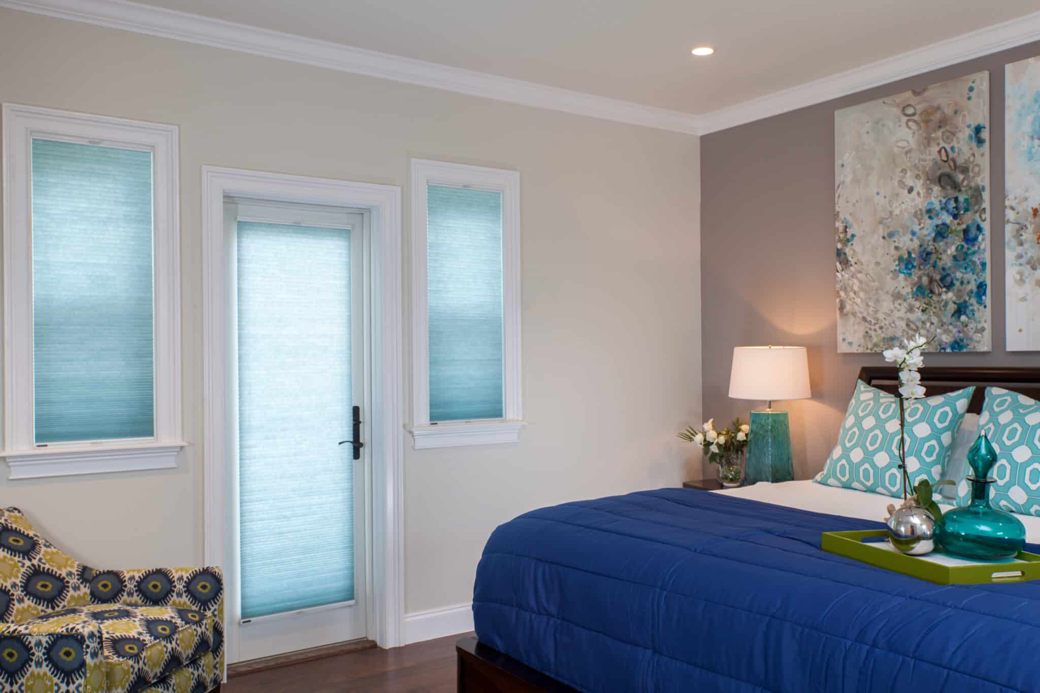Modern bedroom with teal honeycomb blinds in Adelaide home, paired with contemporary décor and blue bedding.